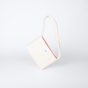 mini sac beige en tissu bouclette posé sur le côté – marque THEANA