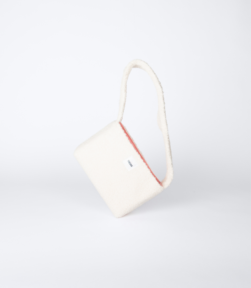 mini sac beige en tissu bouclette posé sur le côté – marque THEANA
