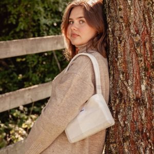 mini sac à carreaux gris porté à l’épaule – marque THEANA