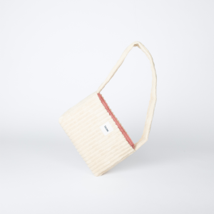 mini sac beige en velours côtelé posé sur le côté – marque THEANA