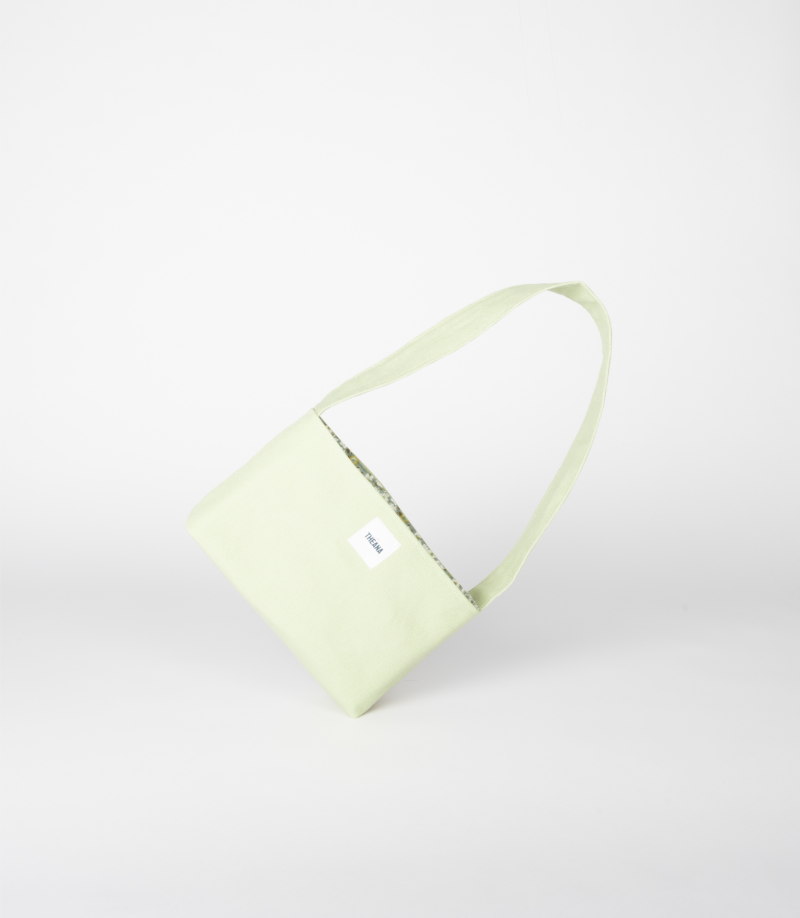 Mini sac en coton vert pomme Theana – mise en scène sur le côté mini sac en coton vert pomme posé sur le côté – marque THEANA